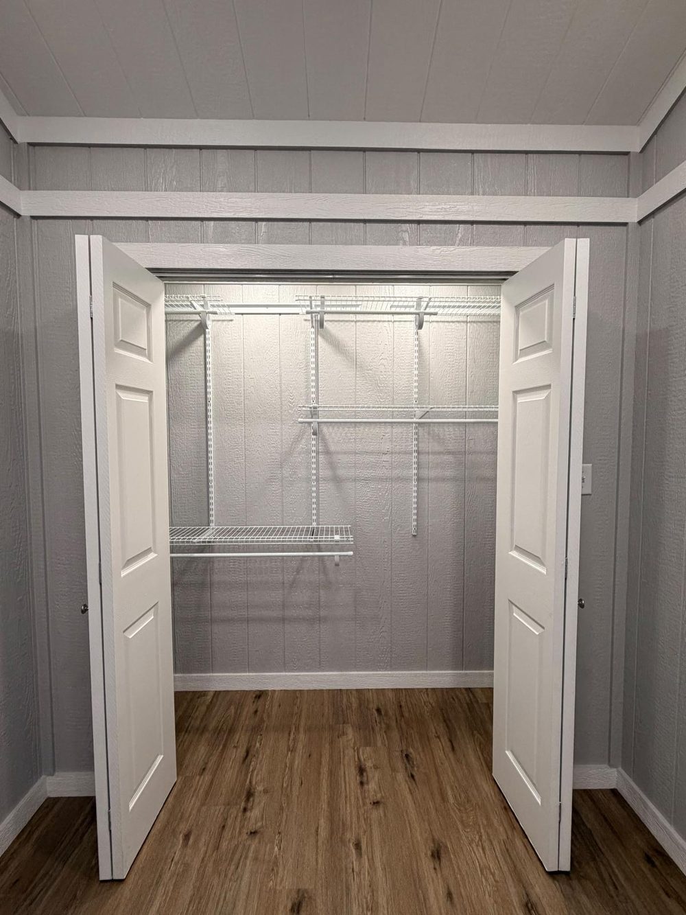 Walk-in closet with wire shelving behind bifold doors